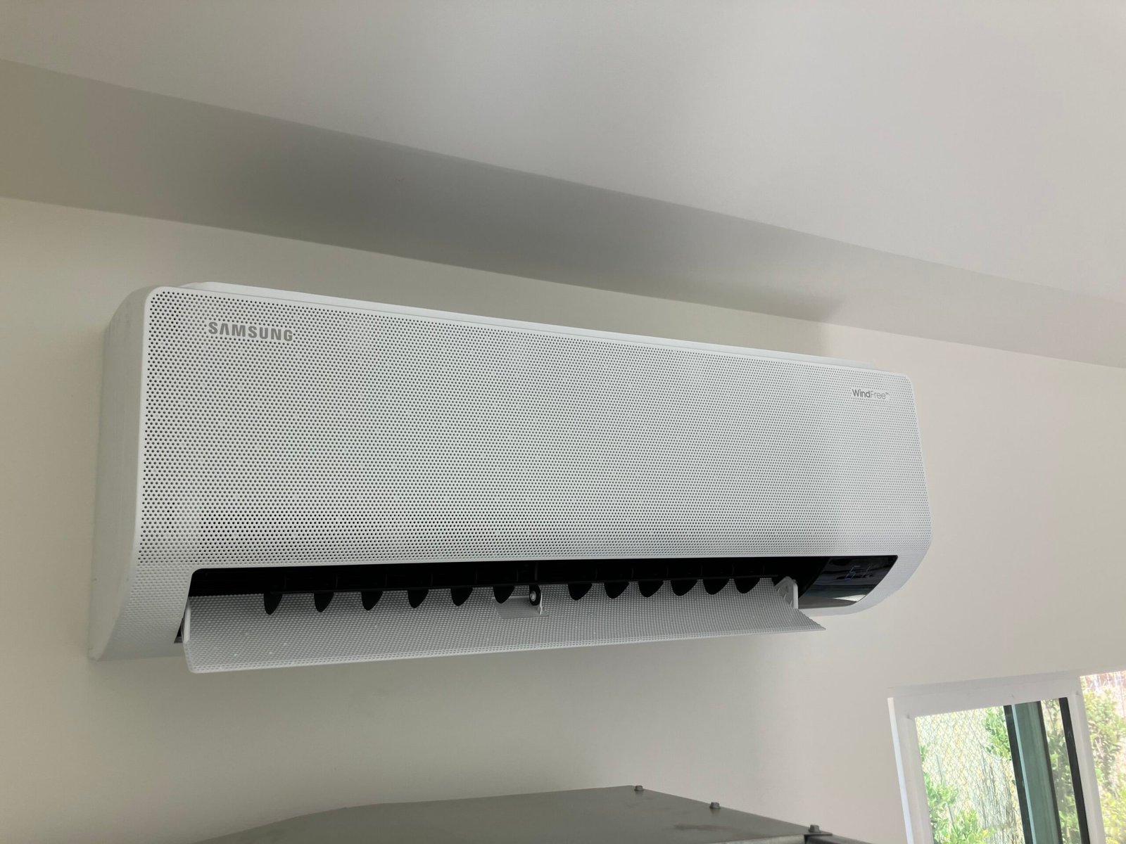 Mini split indoor unit installed above desk in renovated home office space